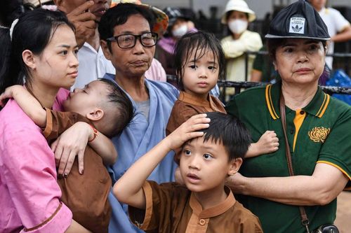 Em bé trên vai mẹ, cụ già trong tay tình nguyện viên đến chiêm bái xá lợi Phật