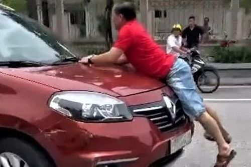 Công an làm việc với tài xế và người đàn ông bám vào capo ô tô chạy giữa phố