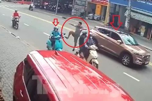 Tài xế dừng ô tô đột ngột giữa đường rồi đạp cô gái đang chạy xe máy ngã nhào