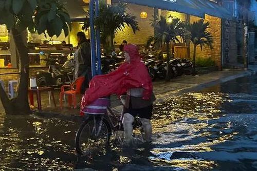 TPHCM mưa xối xả, người dân vất vả lội nước về nhà
