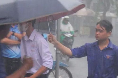Tình nguyện viên dầm mưa hỗ trợ thí sinh