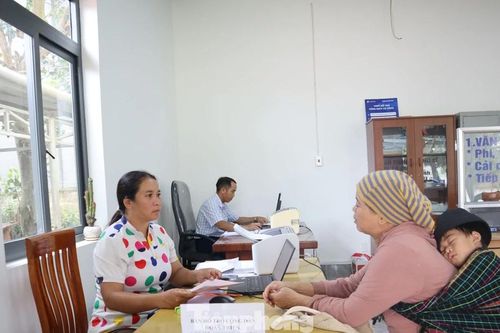 Cán bộ xã dùng song ngữ giúp dân làm thủ tục hành chính
