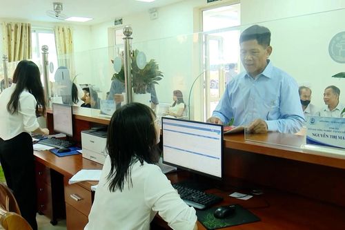 Người dân nhận sổ đỏ khi làm thủ tục tại cấp xã
