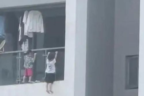 Thót tim cảnh 2 bé trai leo ra ngoài ban công tầng 13, làm động tác 'hít xà đơn'