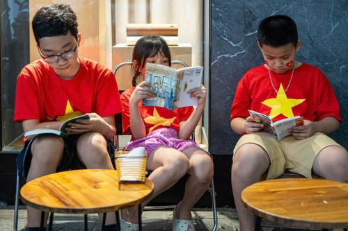 Người dân đọc sách trong lúc chờ xem duyệt binh