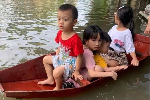 Bi hài đưa con đi học bằng thuyền giữa phố ngập như sông