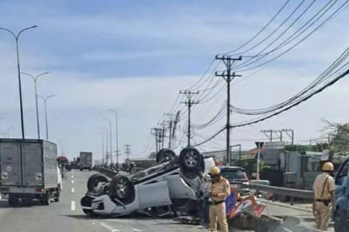 Ô tô chở 4 người lật ngửa trên dốc cầu Bình Thuận