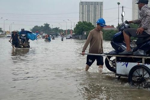 Nhiều tuyến đường ở Hà Nội vẫn ngập sâu, dịch vụ 'cõng' xe máy qua đoạn ngập đắt khách
