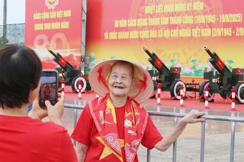 Cụ bà 99 tuổi phấn khởi chụp ảnh cùng pháo lễ ở Mỹ Đình