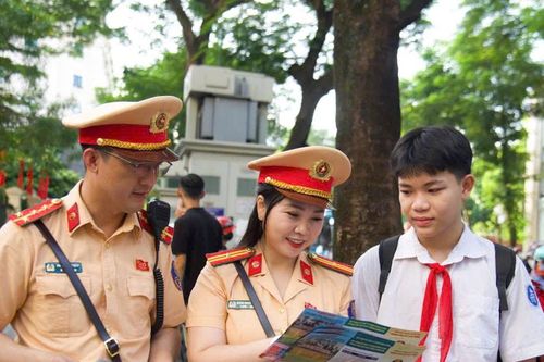 Cảnh sát giao thông Hà Nội phát tờ rơi hướng dẫn an toàn giao thông tới phụ huynh và học sinh trong ngày khai giảng