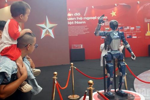 Khách tham quan thích thú tương tác với robot hình người tại Triển lãm 95 năm Cờ Đảng soi đường