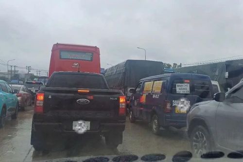 Quốc lộ 1K ùn ứ kéo dài, người dân chật vật di chuyển trong mưa