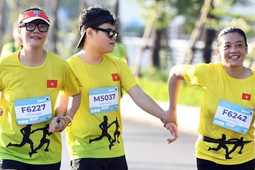 Người khiếm thị được dắt tay ở giải chạy bên Hồ Tây