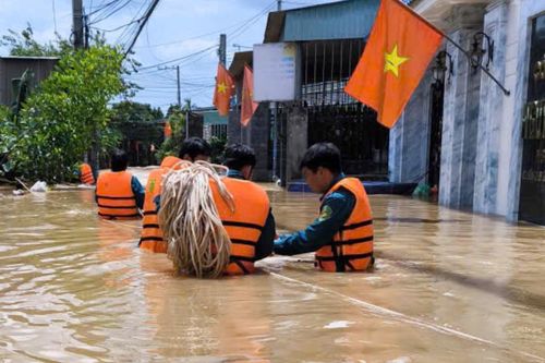 Khu dân cư bị ngập, dân quân cõng người phụ nữ qua dòng nước chảy xiết
