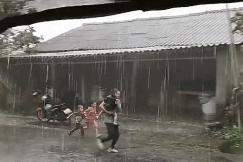 Người cha ôm con đi tránh bão