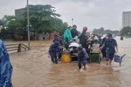 Nước ngập sâu tới ngực, các chiến sĩ Cảnh sát biển giúp người dân đi đường