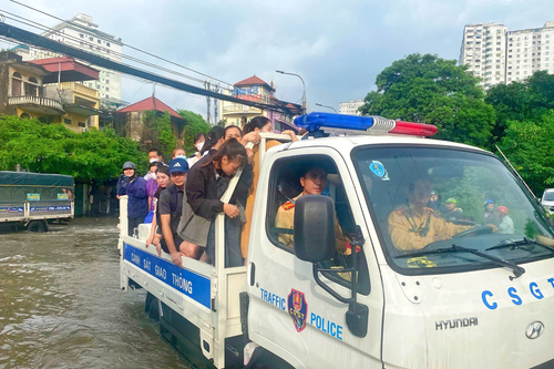 Cảnh sát giao thông Hà Nội hỗ trợ người dân di chuyển an toàn qua điểm ngập úng