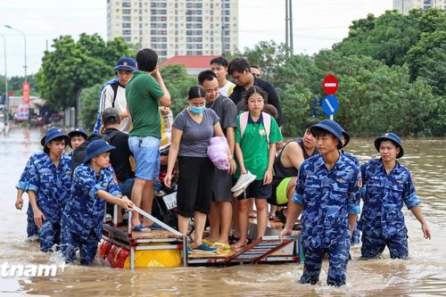 Cảnh sát biển hỗ trợ người dân di chuyển qua vùng ngập sâu khu vực cầu Ngà