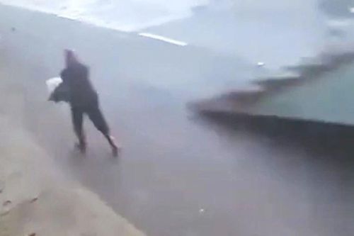 Tấm tôn lớn bị lốc thổi bay, suýt chém trúng người phụ nữ trên đường