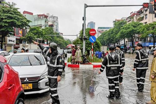 Cảnh sát Cơ động Hà Nội hỗ trợ người dân an toàn đi qua vùng nước ngập