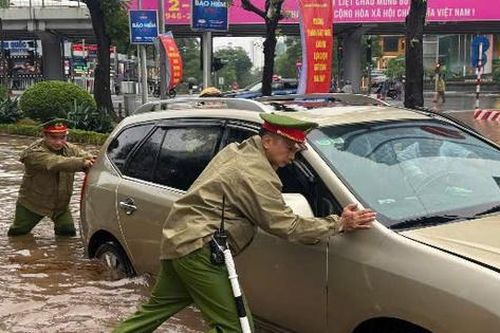 Công an Hà Nội dầm mưa phân luồng, hỗ trợ người dân qua vùng ngập