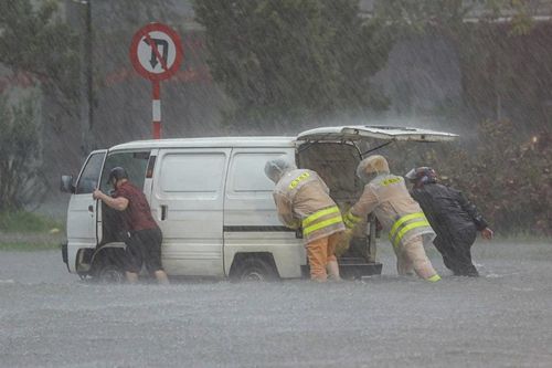 CSGT Hà Nội giúp người phụ nữ đi điều trị bệnh trong mưa bão