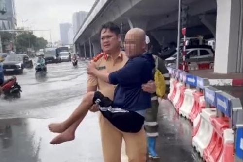 Cán bộ Phòng CSGT Công an TP Hà Nội giúp người nhiều dân đi điều trị bệnh trong mưa bão