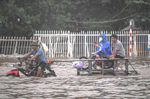 Mưa lớn biến Mỹ Đình thành biển nước, dân trả trăm nghìn thuê kéo xe qua điểm ngập