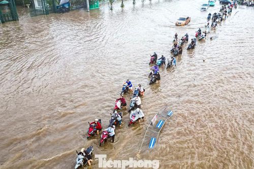 Xe máy 'rẽ sóng' giữa phố, tìm đường lên cao tốc tránh ngập tại Hà Nội