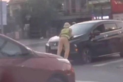 CLIP: Ô tô lao nhanh khi một cảnh sát giao thông bám trên nắp capo