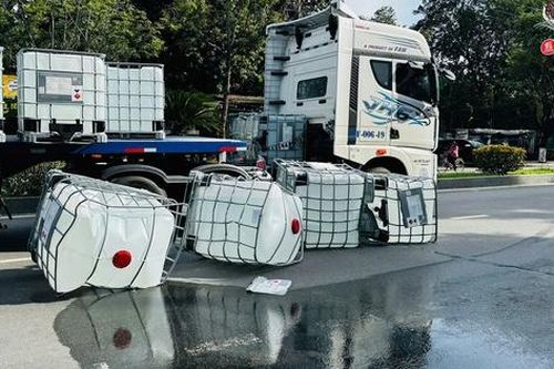 Quảng Ngãi: Xe đầu kéo chở nhiều thùng nghi axit không chằng buộc đổ xuống đường