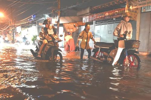 Triều cường dâng cao, người dân bì bõm lội nước về nhà
