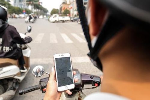 Một thanh niên bị xử phạt vì vừa lái xe vừa lướt điện thoại