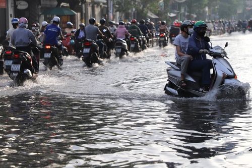 Người dân TPHCM xắn quần, co chân vượt đường ngập lênh láng vào giờ cao điểm