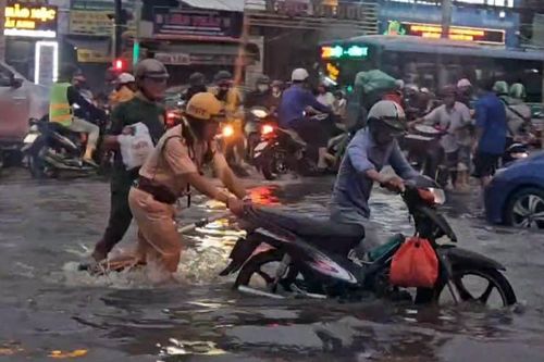 TP Hồ Chí Minh: Ấm lòng hình ảnh CSGT hỗ trợ người dân qua điểm ngập