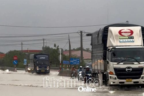 Cảnh sát giao thông xã Thuận Nam hỗ trợ người dân vượt đoạn ngập trên Quốc lộ 1