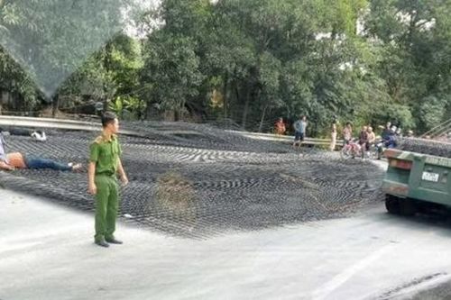 Hàng tấn thép lưới rơi từ xe đầu kéo xuống đường đè 2 người đi xe máy