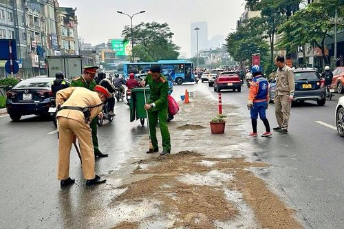 Kịp thời xử lý vết dầu loang trên phố Hà Nội khi trời đang mưa