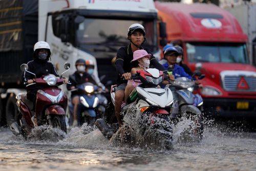 Triều cường đạt đỉnh giờ tan tầm, người TP.HCM lại bì bõm lội nước về nhà