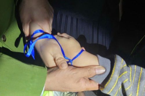 Mẹ buộc tay mình và tay con bằng dây màu xanh, ý định tiếp đó khiến nhiều người hoảng sợ