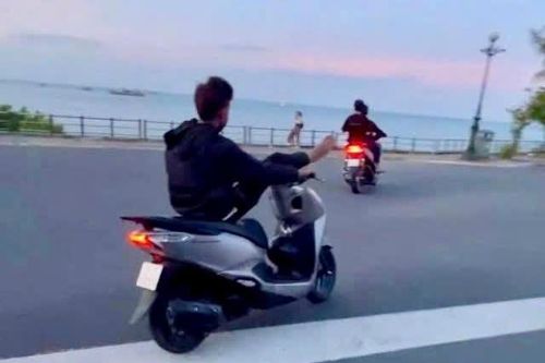 Con gác chân lên đầu xe máy di chuyển trên đường, hai cha con cùng bị phạt