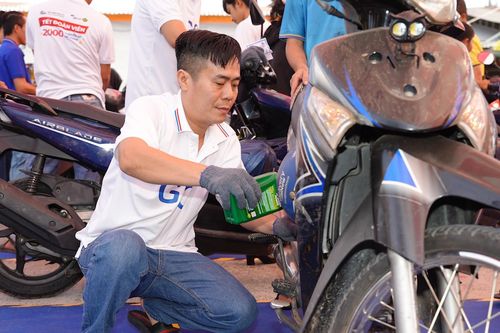 Công nhân vui mừng được thay nhớt xe máy miễn phí trước khi về quê đón Tết