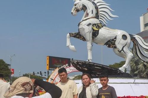 Du khách đến Đà Nẵng thích thú check-in cùng hai linh vật Kim Mã bên cầu Rồng