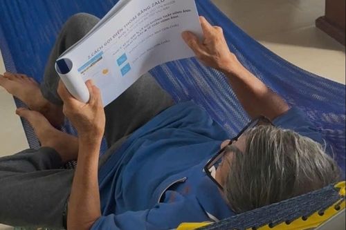 Cháu gái làm tập tài liệu hướng dẫn sử dụng điện thoại cho ông bà