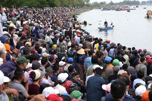 Hàng nghìn người dân và du khách chen chân ken đặc, hò reo cổ vũ đua thuyền trên sông Thu Bồn