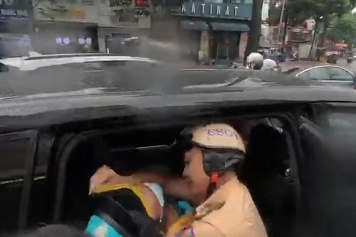 CSGT TP.HCM dẫn đường taxi đưa tài xế xe ôm công nghệ bị đột quỵ đi cấp cứu trong mưa