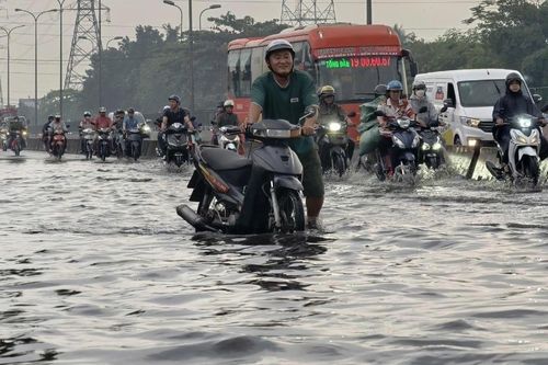 Mưa trái mùa 'nhấn chìm' cửa ngõ TPHCM, người dân bì bõm vượt nước đen về nhà