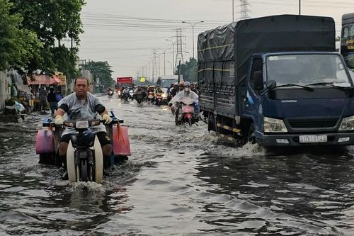 Mưa trái mùa, người dân TP HCM bì bõm trong nước ngập