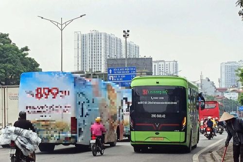 2 xe ô tô khách cỡ lớn dán kín quảng cáo chạy trên đường phố Hà Nội