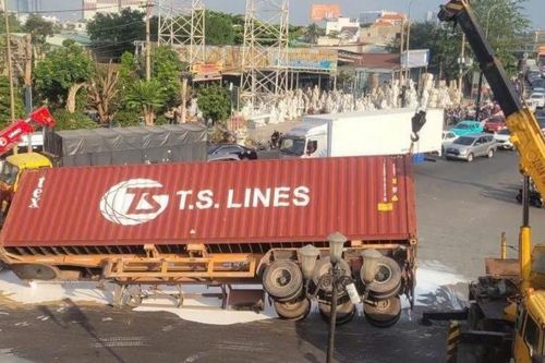 Xe container lật ngang giữa vòng xoay 'tử thần', sơn nước nhuộm trắng mặt đường